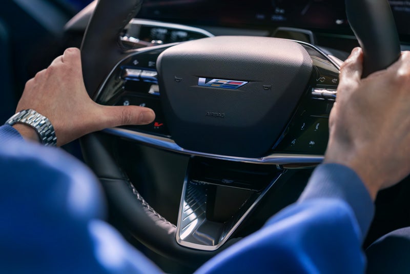 Close-up of a Man About to Press the V-Button on the 2026 OPTIQ-V Steering Wheel | Bachman-Bernard Cadillac in GREENEVILLE TN