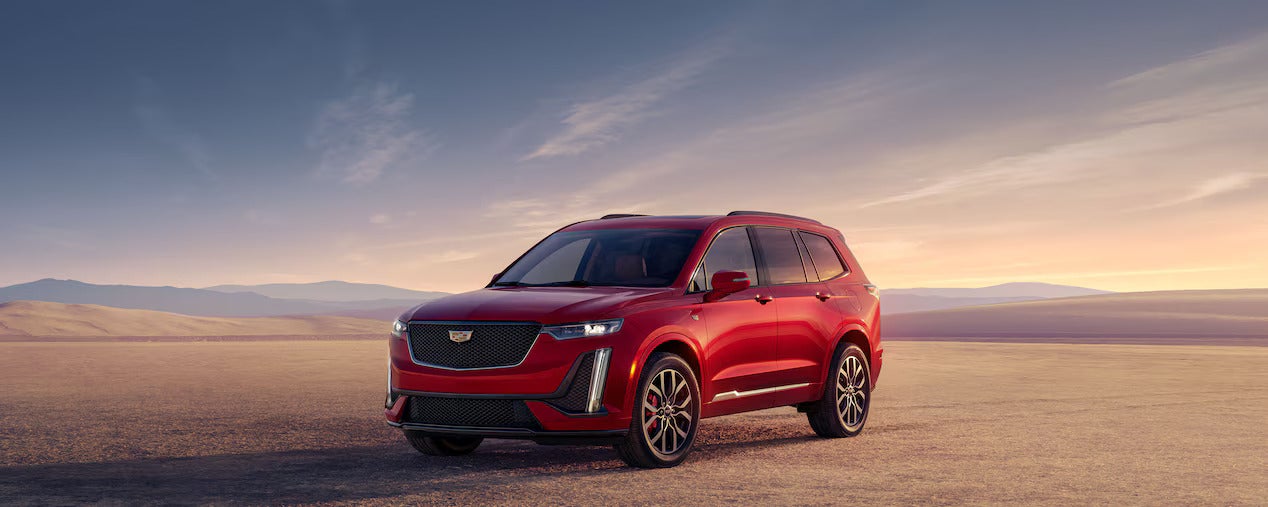 Red luxury Bachman-Bernard Cadillac parked in desert at sunset