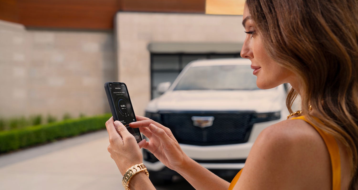 lady checking her mobile with a Cadillac vehicle background | Bachman-Bernard Cadillac in GREENEVILLE TN